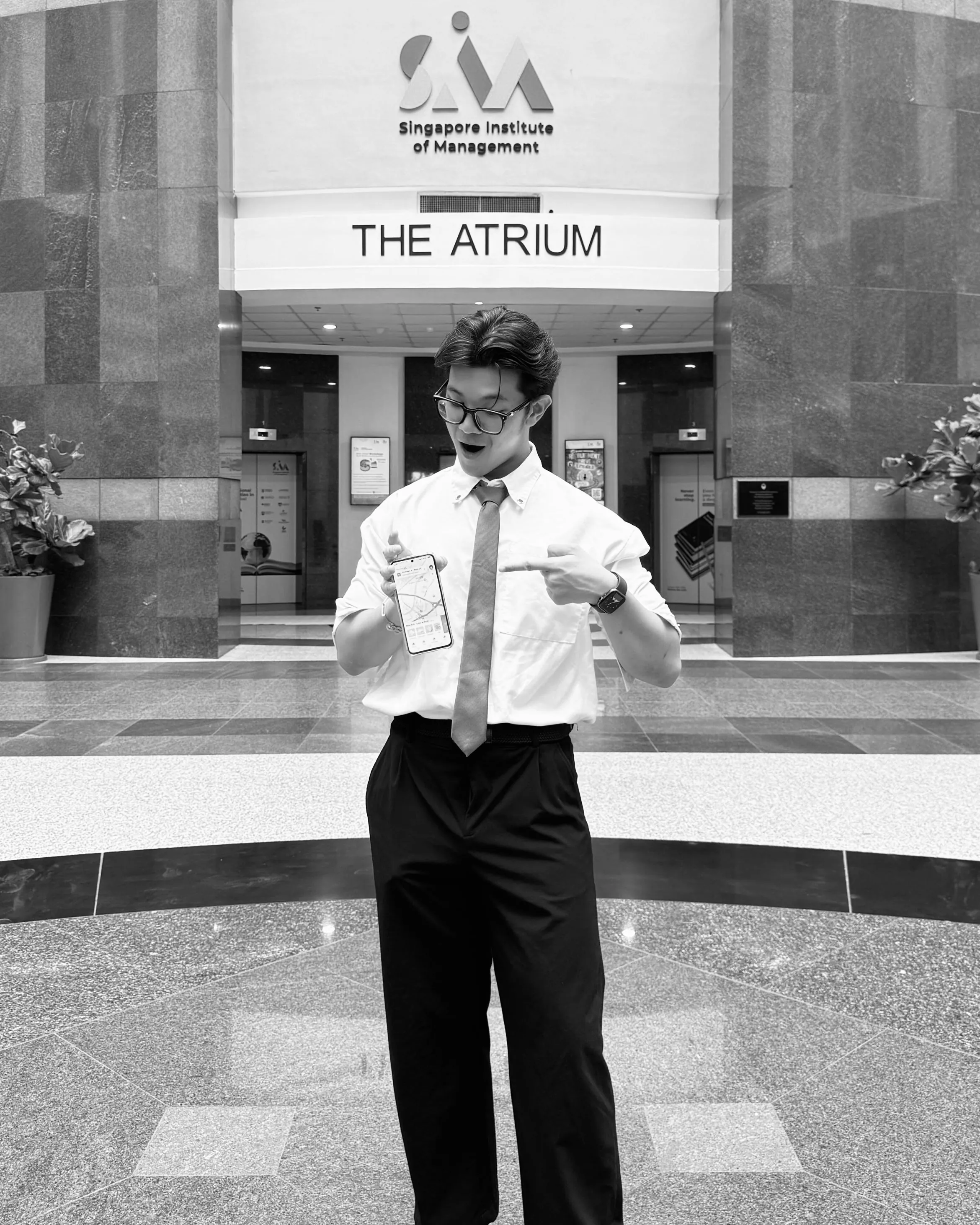 At SIM's Atrium, holding up a phone